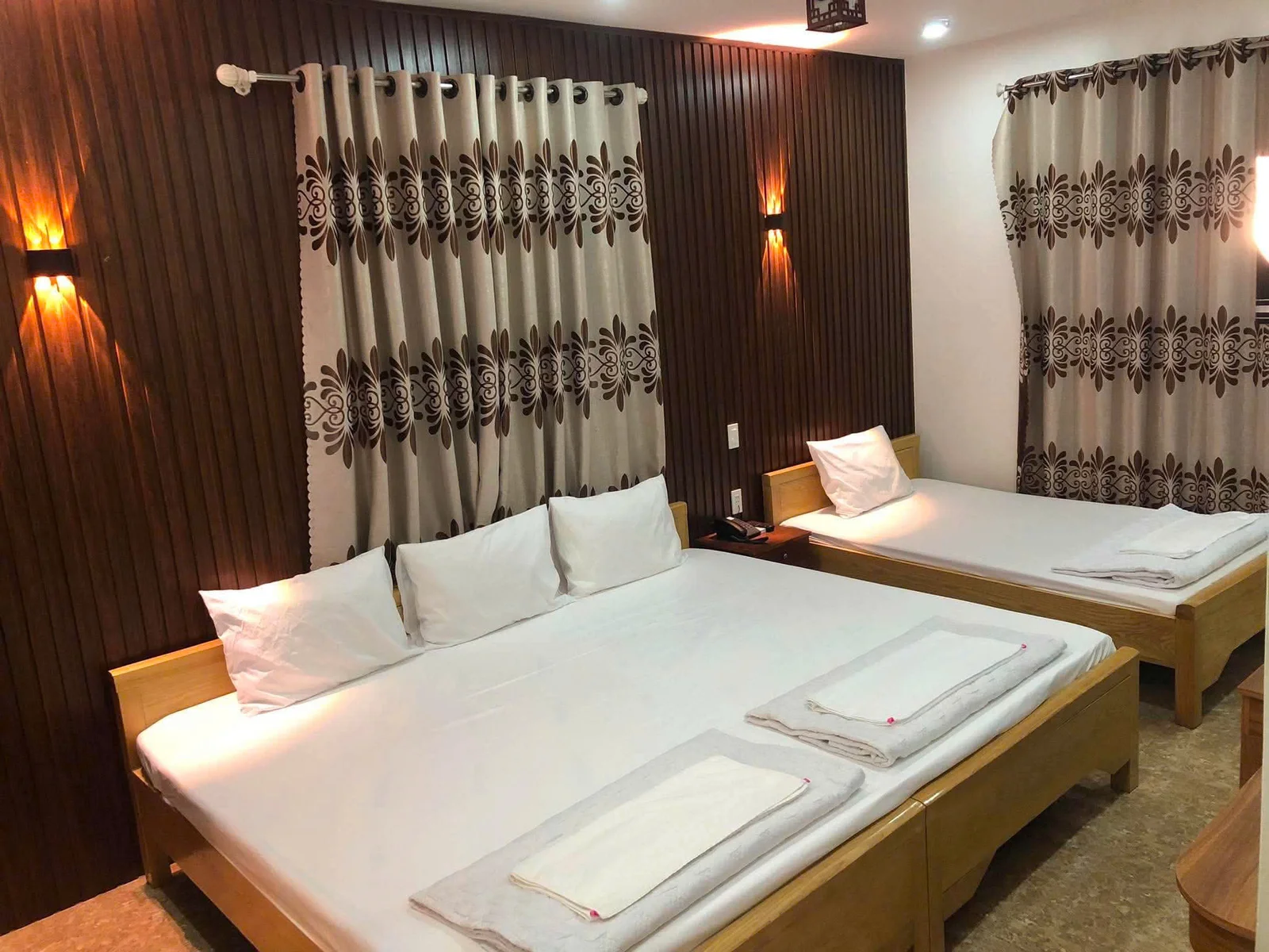 Hai giường và nội thất gỗ trong phòng Family tại Khánh Gia Hotel